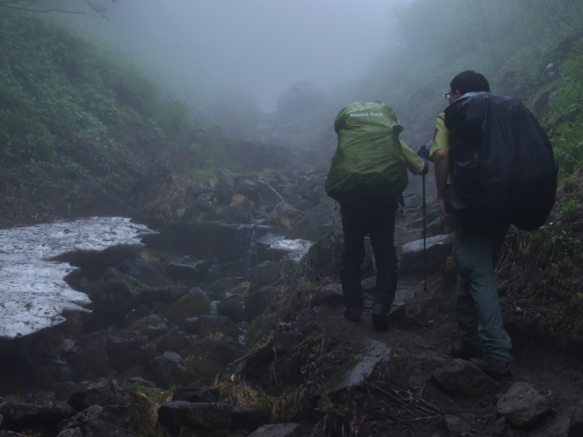 写真＿雨の中を歩く職員