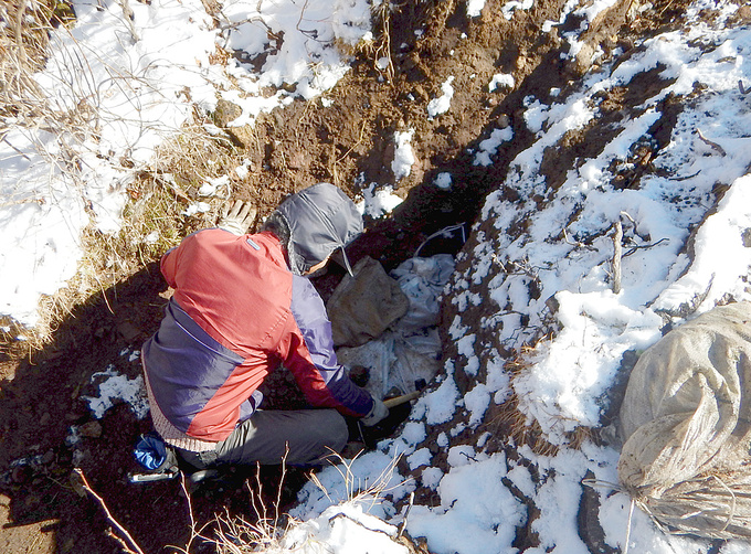 土嚢袋を穴に敷き詰めていく